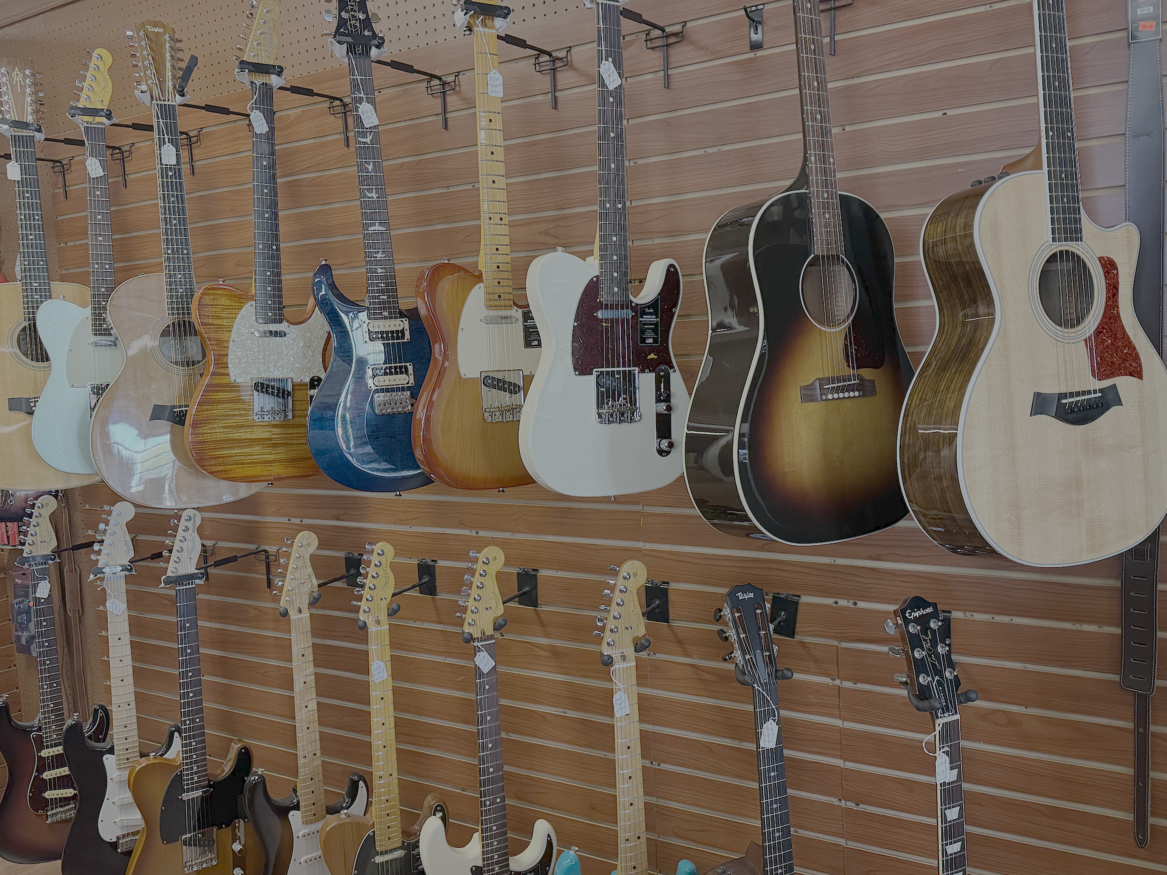 lots of high end guitars on the wall